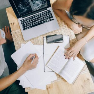 a laptop on a desk with papers