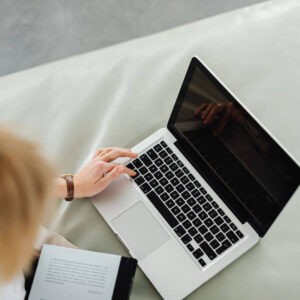 a woman working on a laptop on a couch